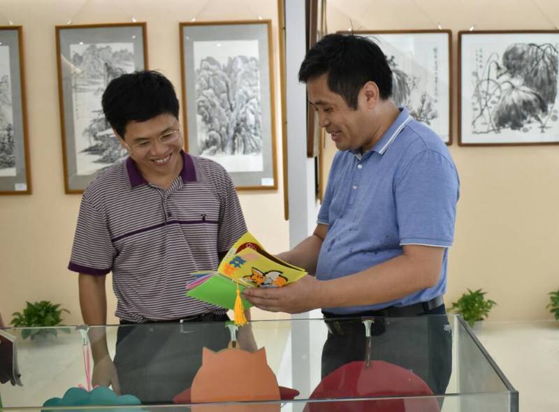 2018年9月14日校长韩峻峰（左）参观教育学院第一届师生书画作品展。